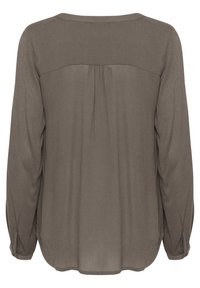 Långärmad blus i taupe med en slät textur, som har en veckning på baksidan och knappdetaljer på ärmarna. Avslappnad passform.