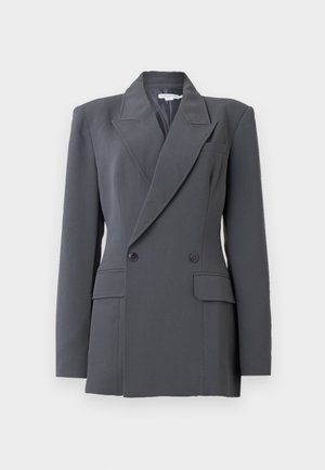 Blazer gris foncé croisé avec épaules rembourrées, revers crantés, deux poches à rabat à l'avant et deux boutons visibles de chaque côté.