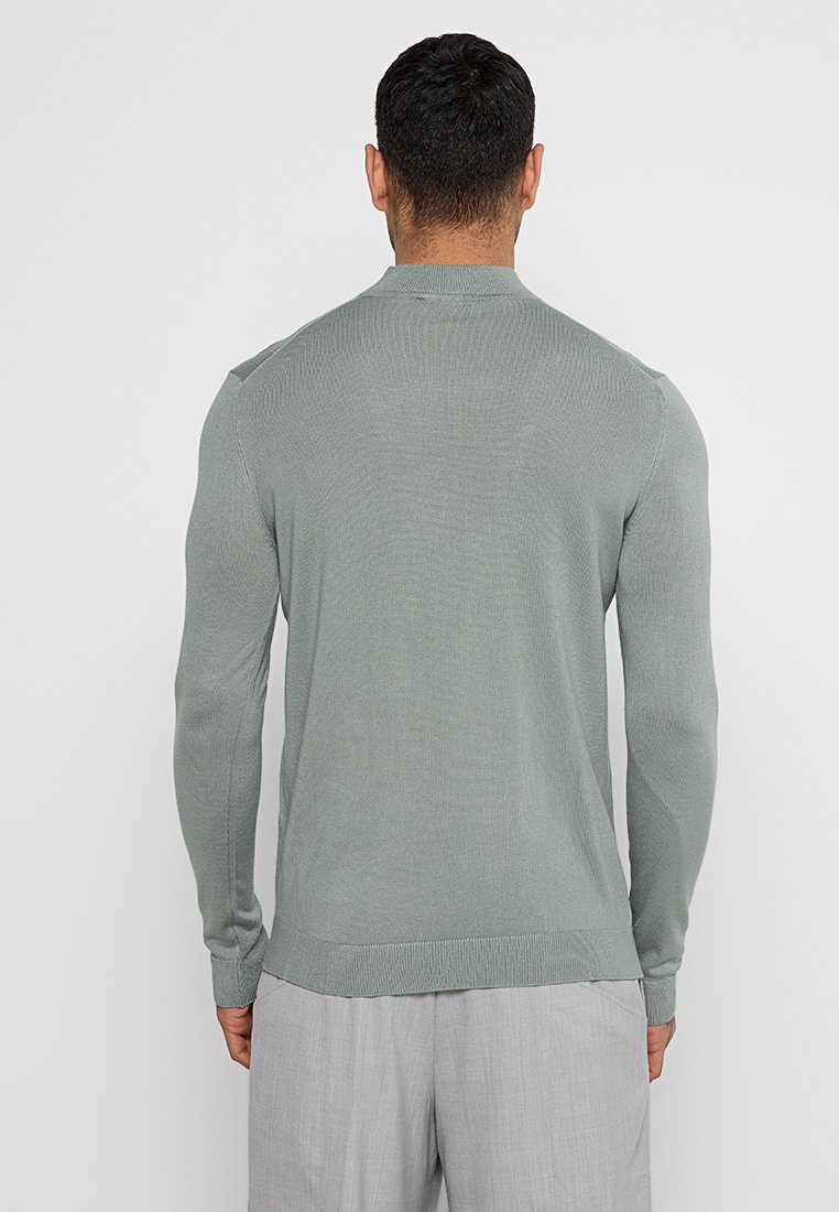 Helle grüne Langarmpullover mit geripptem Muster, runder Halsöffnung und schmaler Passform. Besitzt ein schlichtes Design sowie elastische Bündchen und Saum.