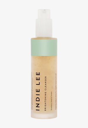 Bouteille en plastique transparente avec une finition givrée, contenant un nettoyant beige. Présente une étiquette turquoise et un distributeur à pompe blanc. Le texte affiche en grande pompe "INDIE LEE BRIGHTENING CLEANSER."