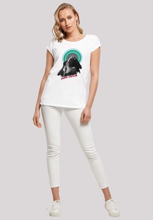 Weißes Baumwoll-T-Shirt mit einem schwarz-weißen Grafikdesign einer Frau, umgeben von mehrfarbigen konzentrischen Kreisen und dem Text "JANIS JOPLIN."
