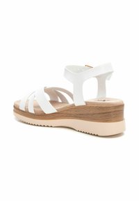 Sandalias de cuña blancas con múltiples correas cruzadas, parte superior texturizada, plantilla acolchada y un acento de imitación de grano de madera en el talón de cuña.