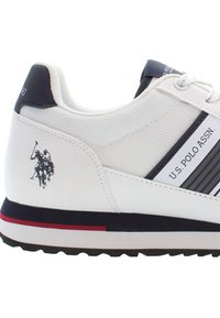 Sneaker bianche con parte superiore in rete testurizzata, dettagli in blu navy, design a righe e logo del giocatore di polo ricamato. Suola in gomma con dettagli a striscia rossa.