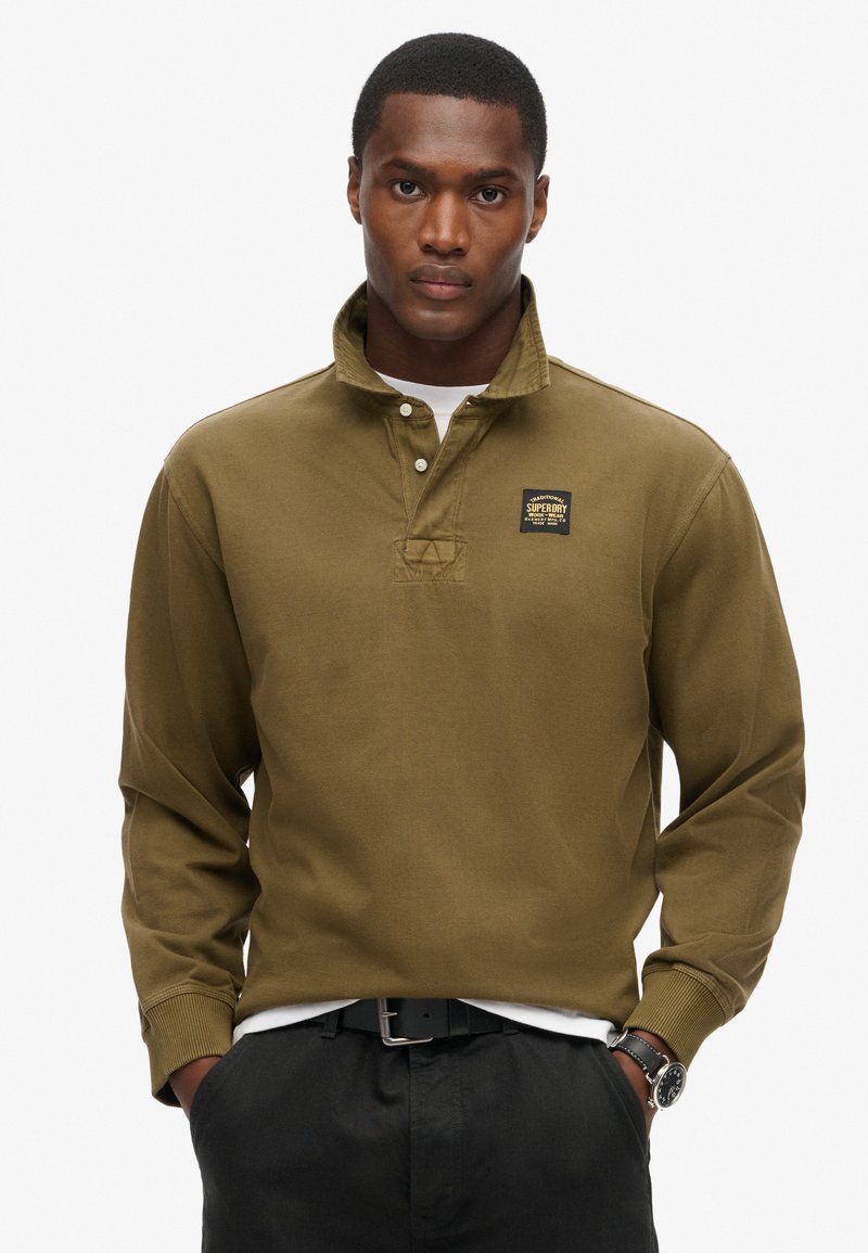 Olivgrünes Langarm-Polohemd mit Kragen, drei Knöpfen und einem Logopatch. Verfügt über einen strukturierten Stoff und gerippte Bündchen.