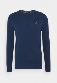 Dunkelblaues, gestricktes Sweatshirt mit langen Ärmeln und Rundhalsausschnitt. Mit kleinem weißen Logo auf der Brust sowie gerippten Bündchen und Saum.