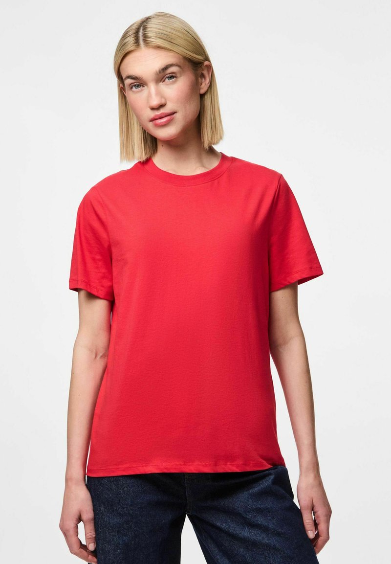 Rød bomulds T-shirt med korte ærmer, rund hals og en afslappet pasform. Glat tekstur og enkelt design, parret med mørke denim jeans.