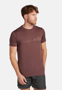 Burgunderfarbene Kurzarm-T-Shirts aus weichem Stoff mit einer einfachen weißen Campinggrafik eines Zeltes und Feuers auf der Brust.