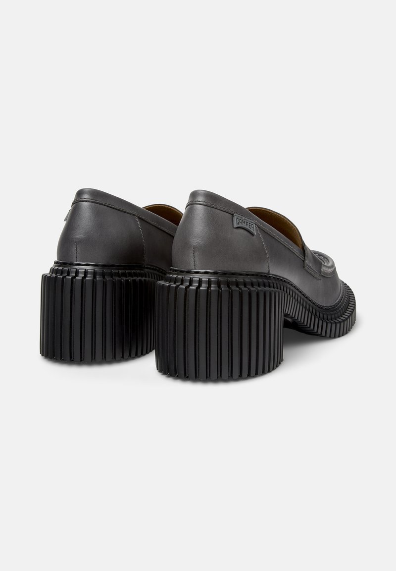 Graue Lederschuhe mit einem abgerundeten Design und einem gerippten schwarzen Absatz. Sie verfügen über eine glatte Oberfläche und ein sichtbares Markenschild an der Seite.