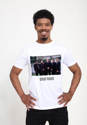 Witte katoenen t-shirt met een voorkantafbeelding van vijf mannen in donkere pakken. "The Sopranos" tekst in grijs onder de afbeelding.
