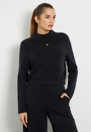 Zwarte sweatshirt met lange mouwen en een hoge hals, voorzien van een kleine driehoekige metalen accenten en een relaxed fit, met een elastische taille.