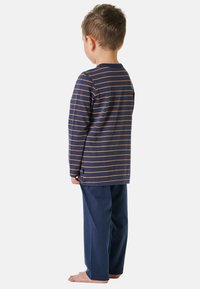 Navy blue pajama set featuring a long-sleeve striped top with orange lines and matching navy pants, made from soft cotton fabric.