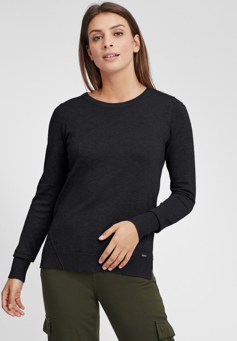 Maglione nero a maniche lunghe con scollatura rotonda e polsini a costine, con dettaglio di spacco laterale e una piccola accentatura con logo vicino all'orlo.