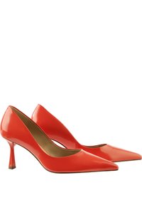 Red patent leather high heels with a pointed toe and a tapered stiletto heel; smooth texture with a shiny finish.
