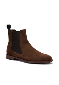 Stivale Chelsea in suede marrone con pannelli laterali elastici, punta arrotondata e suola piatta in legno, dotato di linguetta sul retro.