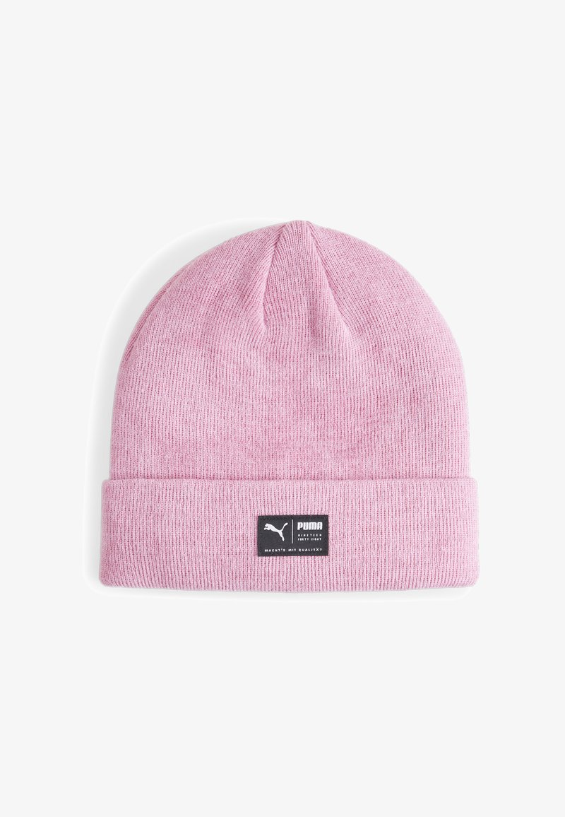 Light pink knitted beanie with a folded cuff, featuring a black rectangular tag with white logo text. Soft texture, simple, rounded top design.