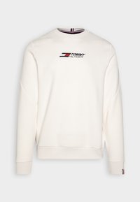 Felpa bianca realizzata in tessuto morbido con scollo rotondo e spalle scese. Presenta un logo stampato nei colori blu navy, rosso e bianco.