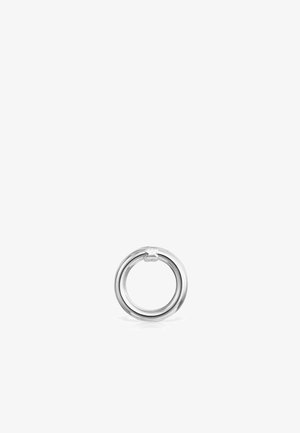 Bague en argent avec une surface lisse et polie et un design entrelacé. Présente un petit emblème à un point de connexion. Forme circulaire.