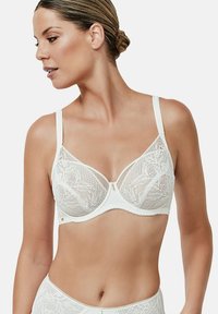 Witte kanten bh met zachte cups, bloemenpatroon, verstelbare bandjes en een decoratief detail in het midden. Glad onderband voor comfort.