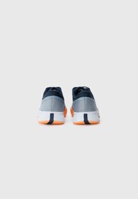 Graue und marineblaue Sportschuhe aus strukturiertem Stoff, mit orangen Gummisohlen und abgerundeter Form. Sie verfügen über ein niedrig geschnittenes Design und eine verstärkte Ferse.