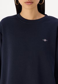 Sweatshirt blu navy realizzato in morbido cotone, con scollo a squadra e un piccolo logo ricamato sul petto. Design a vestibilità rilassata.