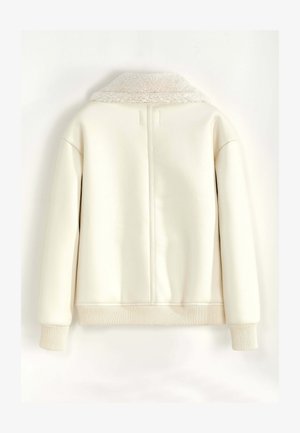 Veste couleur crème avec un col doux et moelleux, des poignets et un ourlet côtelés. Présente un matériau extérieur lisse et texturé ainsi qu'un design minimaliste.