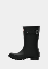 Μαύρο καουτσούκ βροχοBoot με στρογγυλή μύτη, υφασμάτινη σόλα και ρυθμιζόμενο λουράκι στο πλάι. Λείο φινίρισμα, σταθερό χαμηλό τακούνι.