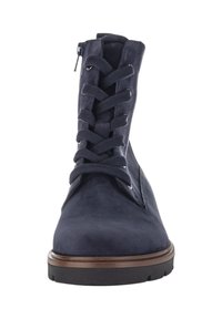 Stivale in suede blu navy con lacci, suola in gomma nera e rifiniture marroni, mostrato da una vista frontale con cerniera laterale.