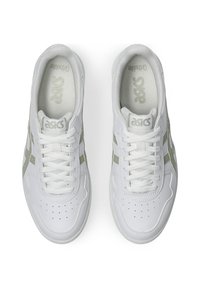 Białe buty sportowe z gładkiej skórzanej cholewki, z jasnoszarymi akcentami, okrągłym noskiem i płaskimi sznurowadłami. Perforowana detal na nosku.