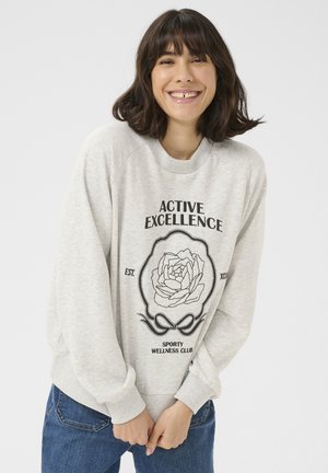 Felpa grigia chiara con scollo rotondo e maniche raglan. La parte frontale presenta un testo nero e un design floreale sul tessuto.