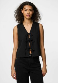 Juoda be rankovių palaidinė su giliu V formos iškirpimu, priekyje puošni trimis surišimais. Lygus audinys, trumpinta forma, derinama su juodomis kelnėmis.