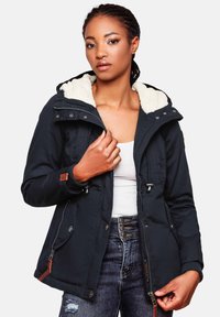 Navy blue winter jacket with a fluffy white lining, zip closure, front pockets, adjustable drawstrings, and textured fabric.