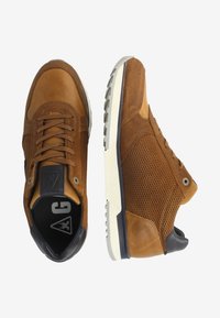 Sneakers in suede marrone e mesh con punta rotonda, lacci piatti e suola bianca testurizzata. Presentano un logo sulla linguetta.