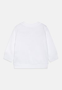 Felpa bianca con maniche lunghe, polsini e orlo a costine, caratterizzata da una texture semplice e liscia e da un classico design a collo rotondo.