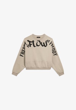 Sweat-shirt court beige avec texte noir « FLOW » et « FREDDY » imprimé sur le devant et les manches. Il comporte un col rond et des poignets côtelés.