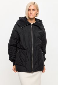 Zwarte pufferjack met een gestructureerde grijze fleece-gevoerde capuchon, ritssluiting aan de voorkant, elastische manchetten en twee zijzakken.