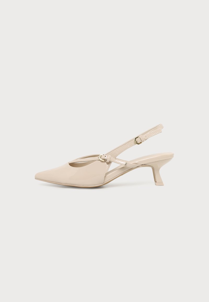 Chaussure slingback beige à bout pointu, avec un petit talon kitten bas et une bride de cheville ajustable sur un fond clair uni.