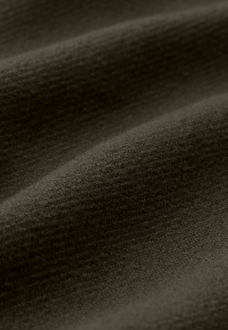 Tissu foncé avec une surface douce et texturée, présentant des vagues subtiles et une teinte uniforme et profonde.