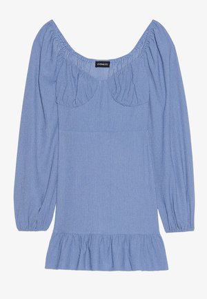 Blå strukturert bluse med lange purrende ermer, bred halsutringning og volangkant. Har rynkede detaljer ved skuldrene og brystet.