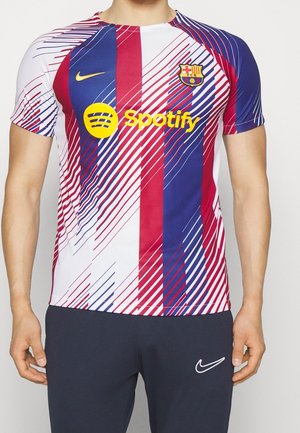Torse masculin portant le maillot de football du FC Barcelone en rouge, bleu et blanc avec le logo Spotify et le swoosh Nike, associé à un pantalon noir Nike.