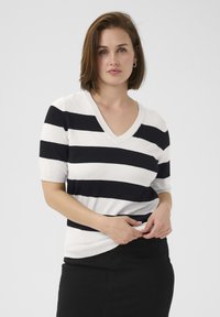 Gestreifter kurzärmeliger Pullover mit V-Ausschnitt, der abwechselnd schwarze und weiße horizontale Streifen zeigt, aus weichem Stoff und mit lockerem Schnitt.