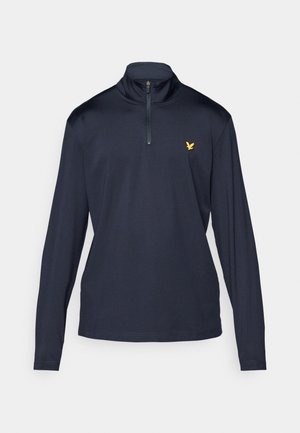 Chemise à manches longues couleur marine avec fermeture éclair quart et col haut. Dotée d'un logo jaune sur la poitrine gauche et en tissu lisse et léger.
