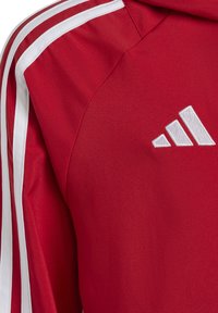 Rode sportieve hoodie met witte zijstrepen, met geborduurd drie-strepen logo op de linkerborst. Soepele stoftextuur.