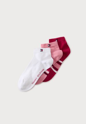 Trois chaussettes chevilles en blanc, rose clair et rose foncé avec de petits logos Tommy Hilfiger sur les bord-côtes et le nom de la marque sur la chaussette blanche.