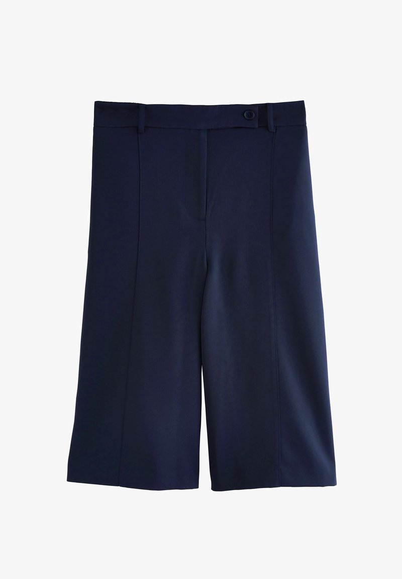 Culottes bleu marine en tissu lisse, avec un devant plat, des poches latérales et une fermeture à bouton à la taille. Design ajusté.