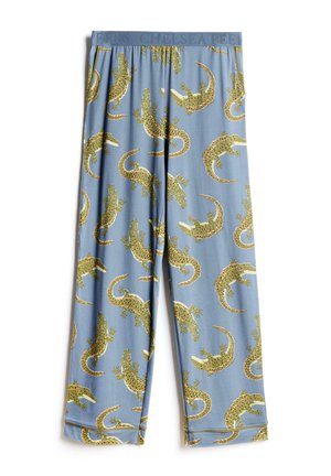 Torso masculino vistiendo pantalones cortos azules con estampados de caimanes verdes y naranjas y una cinturilla gris con texto en relieve.