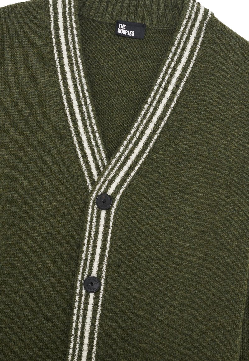 Cardigan en tricot vert avec un col en V, accents de rayures blanches le long du col, et trois boutons noirs sur le devant. Texture douce.