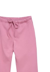 Różowe dresy z elastycznym pasem i regulowanym sznurkiem. Miękki materiał bawełniany, zwężane nogawki i brak widocznych wzorów.