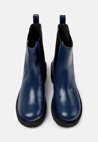 Modré kožené kotníkové boty s lesklým povrchem, elastickými bočními panely a poutky pro snadné obouvání. Černé gumové podrážky se strukturovaným vzorem pro lepší přilnavost.