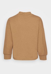 Brauner Strickpullover mit hohem Kragen, überschnittenen Schultern und Dreiviertelärmeln; bietet einen strukturierten Stoff und eine lockere Passform.