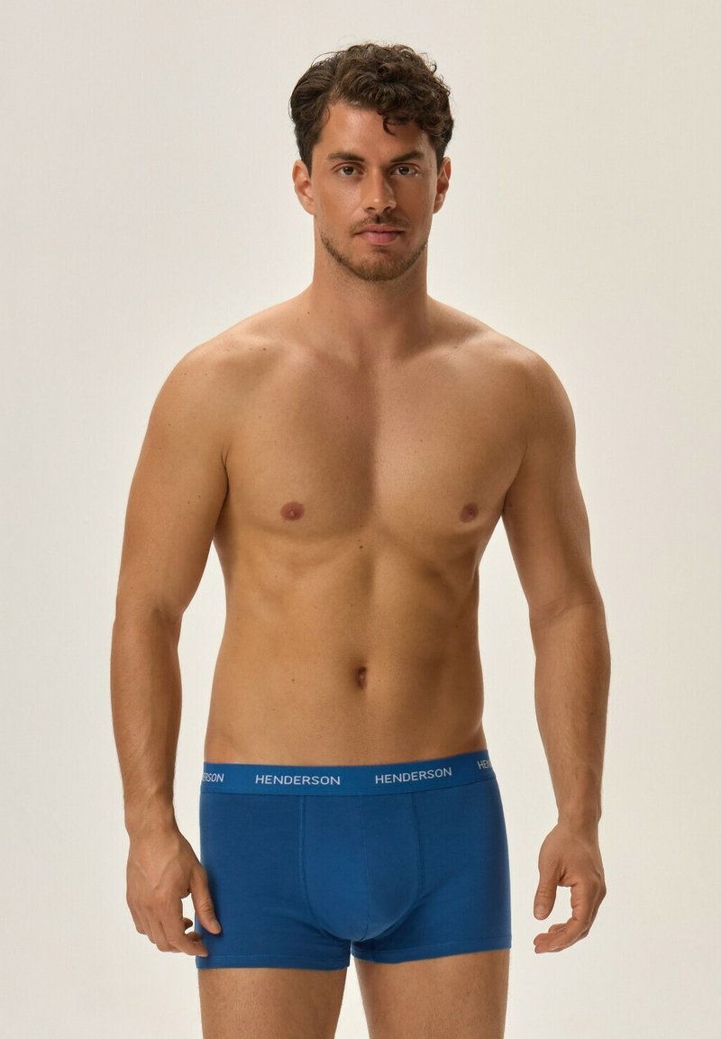 Blue cotton boxer briefs with a fitted design and HENDERSON branding on the waistband, displayed on a model against a neutral background.